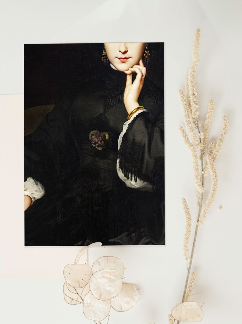 May include: A close-up of a woman's face and hand. She is wearing a black dress with a lace trim and gold earrings. The background is dark.