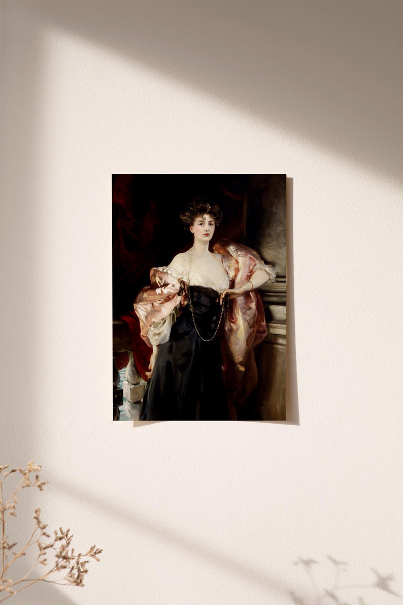 A vintage portrait of a woman in a black gown and a pink shawl draped over her arms is hung on a light-colored wall. Sunlight casts soft shadows across the wall, and a small dried branch is visible in the lower left corner.
