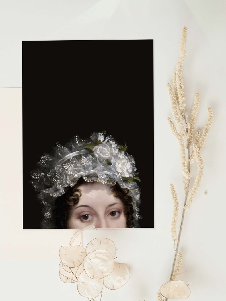 Art print laying on  a white surface. The poster shows the face of a woman at the bottom of it, her head can be seen from the nose up. She is wearing a lace bonnet with white flowers, the background is black.