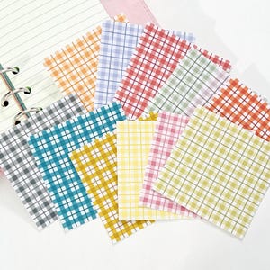 May include: A set of ten colorful gingham patterned paper squares. The squares are arranged in a fan shape and are all different colors, including yellow, orange, red, pink, blue, green, and gray.