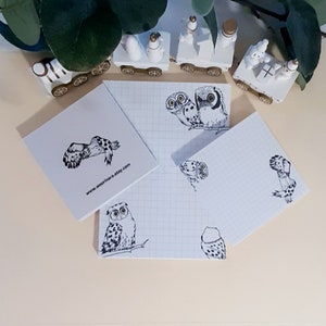 May include: A set of four white notepads with a grid pattern. Each notepad features a black and white illustration of an owl. The notepads are decorated with the text "www.webpinnara.etsy.com".