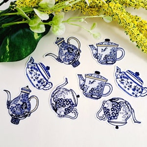 May include: Eight blue and white porcelain teapots with floral and bird designs. The teapots are on a white background.