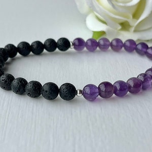 May include: A black lava rock and amethyst beaded bracelet. The bracelet is made with small, round beads and has a silver spacer bead.