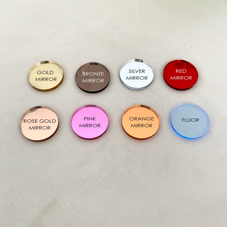 May include: Eight circular acrylic discs arranged in two rows. The top row features gold mirror, bronze mirror, silver mirror, and red mirror. The bottom row features rose gold mirror, pink mirror, orange mirror, and a light blue fluor disc.