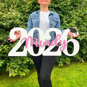 Graduation decor sign used as yard display and photo backdrop for high school graduate