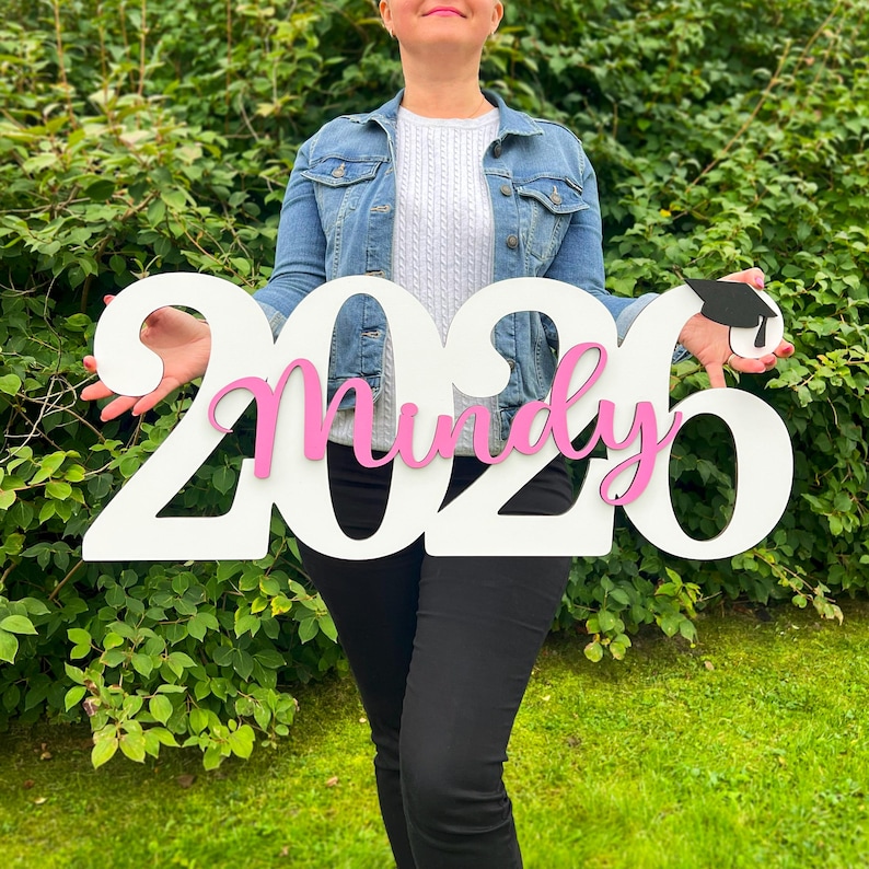 Graduation decor sign used as yard display and photo backdrop for high school graduate