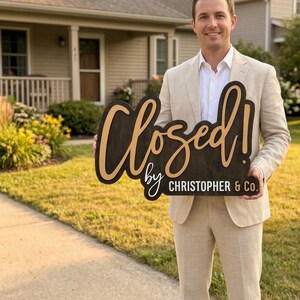 Op de afbeelding: Een donkerbruin houten bord met lichtbruine letters met de tekst Closed! by CHRISTOPHER & Co. Het bord heeft een groot cursief lettertype voor het woord Closed! en een kleiner schreefloos lettertype voor de rest van de tekst.