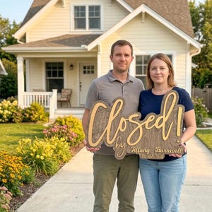 May include: A wooden sign with a dark wood grain finish and light-coloured lettering that reads "Closed! by Tiffany Barnwell 912-665-7040". The sign features a script font for the word "Closed!" and a simpler font for the name and phone number.