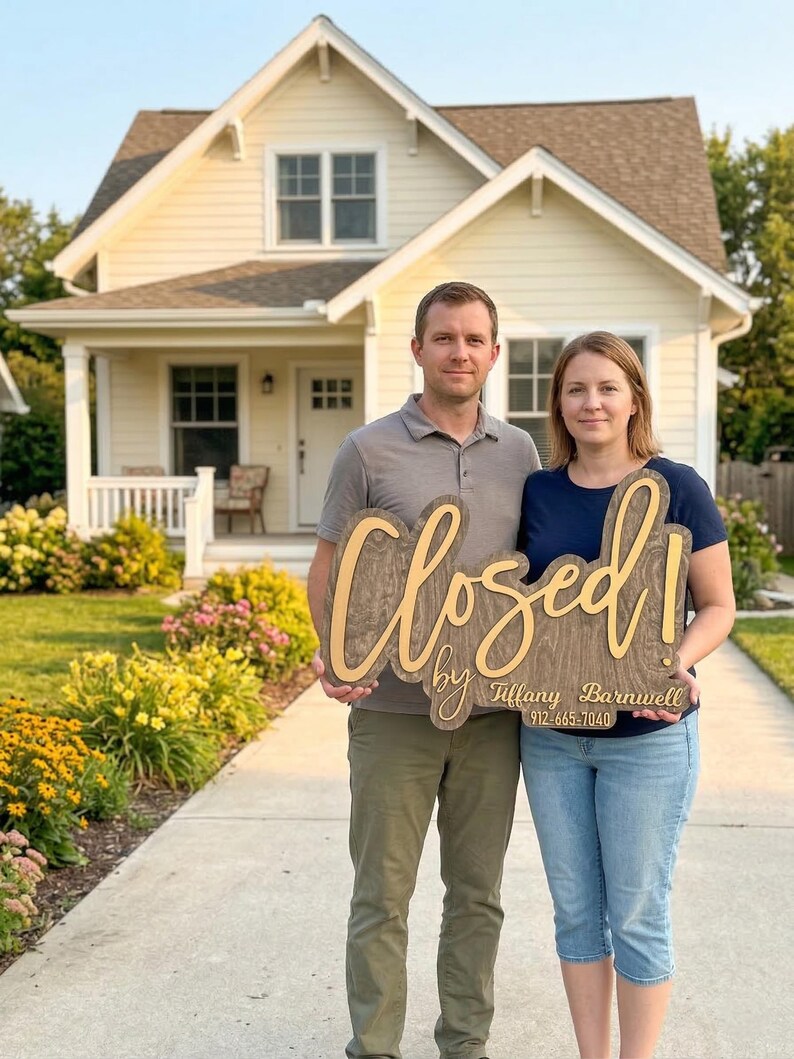 May include: A wooden sign with a dark wood grain finish and light-coloured lettering that reads "Closed! by Tiffany Barnwell 912-665-7040". The sign features a script font for the word "Closed!" and a simpler font for the name and phone number.