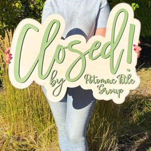 real estate branding sign sold by agent wood