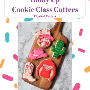 May include: Giddy Up Cookie Class Cutters - Physical Cutters. A set of five cookie cutters in the shape of a cowboy hat, cactus, boots, a shirt, and a disco ball. The cutters are on a wooden cutting board.