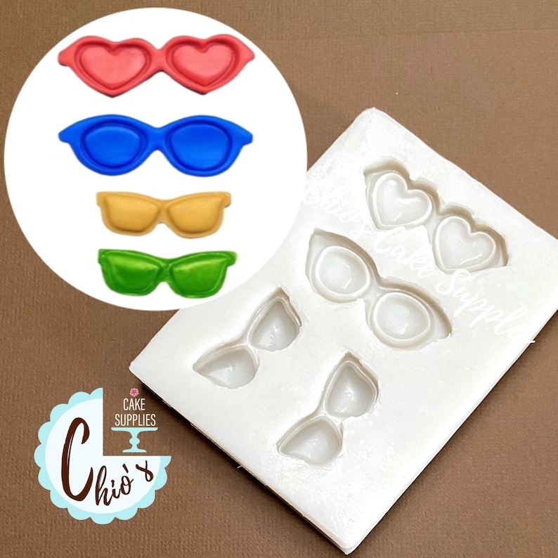 May include: A white silicone mold with various sunglasses shapes, including heart-shaped and classic styles. The image also shows four colorful sunglasses: red heart-shaped, blue, yellow, and green. The logo "Chio's Cake Supplies" is visible.