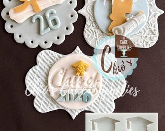 May include: Cake decorations featuring graduation themes. Includes a scroll with a bow, a graduate silhouette with a diploma, and a "Class of 2020" design. Also includes a silicone mold with graduate silhouettes.