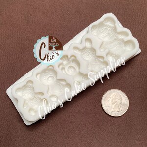 Pu&ograve; includere: Stampo in silicone bianco con cinque cavit&agrave; a forma di orso. Gli orsi hanno disegni dettagliati e misurano circa 2,5 cm. Lo stampo &egrave; mostrato accanto a una moneta da un euro per il confronto delle dimensioni.