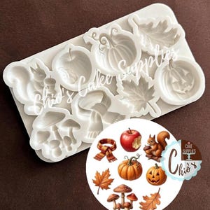 May include: A white silicone mold featuring various autumn-themed cavities including a squirrel, apple, pumpkin, jack-o'-lantern, scarf, maple leaf, oak leaf, and mushrooms. The mold is accompanied by a circular graphic showing the finished designs.