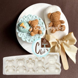 Pu&ograve; includere: Stampo in silicone con cinque cavit&agrave; a forma di orso. Lo stampo &egrave; bianco e gli orsi sono dettagliati con facce sorridenti e un motivo di piccoli cerchi. Lo stampo &egrave; su una superficie marrone.