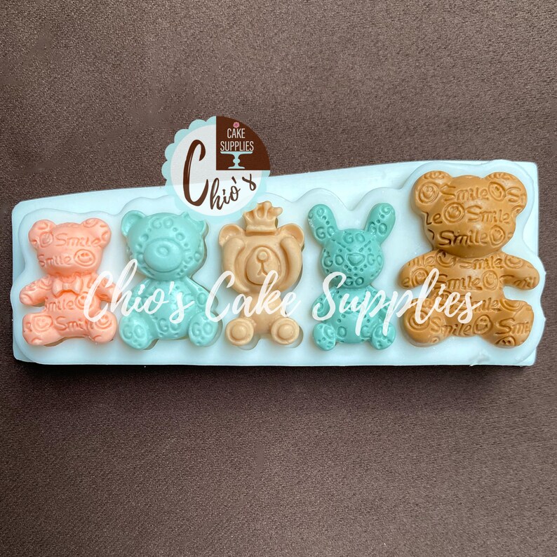 Pu&ograve; includere: Stampo in silicone con cinque cavit&agrave; a forma di orso. Gli orsi sono di colori diversi e hanno diversi motivi. Lo stampo &egrave; bianco e ha la scritta "Chio's Cake Supplies" stampata.
