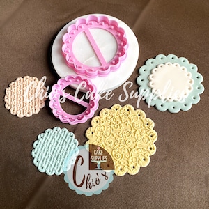 May include: Five round cake decorating tools, including a pink cutter with a handle, a white base with a pink cutter, and three fondant impressions with different patterns. The fondant impressions are light pink, light blue, and yellow.