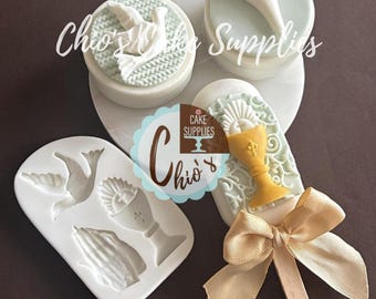 May include: Cake decorating supplies featuring religious-themed molds and decorations. The image shows a white mold with a dove, chalice, and praying hands. There are also finished cake toppers with a dove, calla lily, and chalice with a bow.