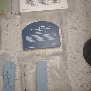 May include: A collection of souvenir cards and plaques featuring historical landmarks. The items include a card for the Jefferson Memorial, a plaque for the White House, and a sign for Famous Street Signs. Each item is in a plastic sleeve.
