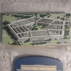 May include: Two souvenir postcards. The top postcard features an aerial view of the Pentagon in green, gray, and white. The bottom postcard depicts the Lincoln Memorial at night with a blue sky and white stars.
