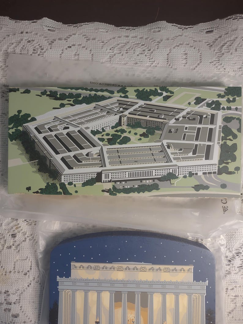May include: Two souvenir postcards. The top postcard features an aerial view of the Pentagon in green, gray, and white. The bottom postcard depicts the Lincoln Memorial at night with a blue sky and white stars.