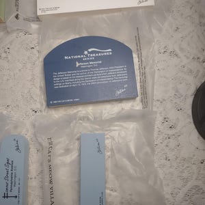 May include: A collection of souvenir cards and tags featuring landmarks and historical sites. The cards include text about the White House, the Jefferson Memorial, and other locations. The items are in clear plastic packaging.