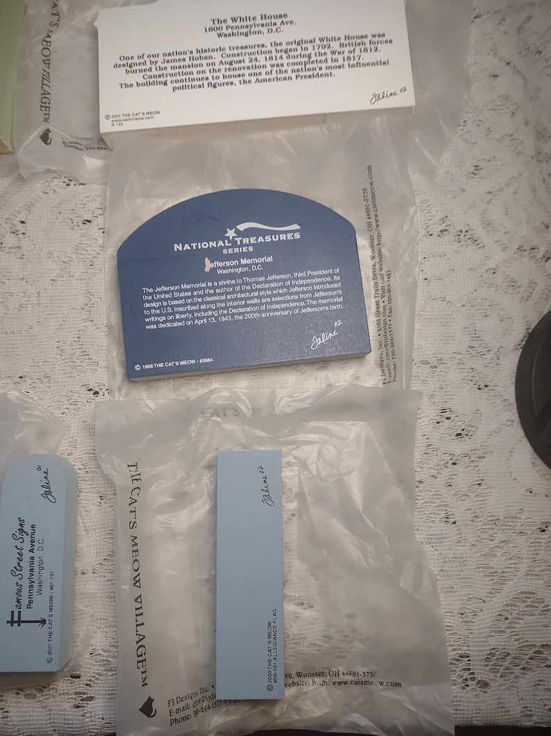 May include: A collection of souvenir cards and tags featuring landmarks and historical sites. The cards include text about the White House, the Jefferson Memorial, and other locations. The items are in clear plastic packaging.