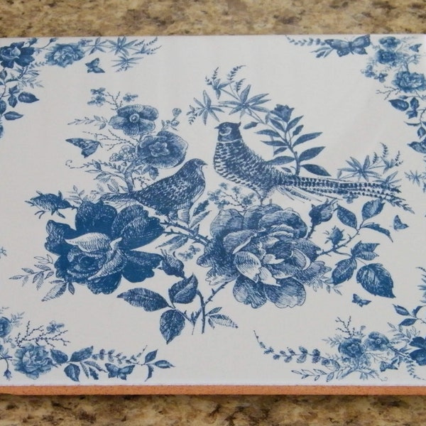 Vintage-style kitchen trivet on ceramic tile. Painting with 2 birds and flowers in blue colors. Retro-style tile trivet in blue colors.