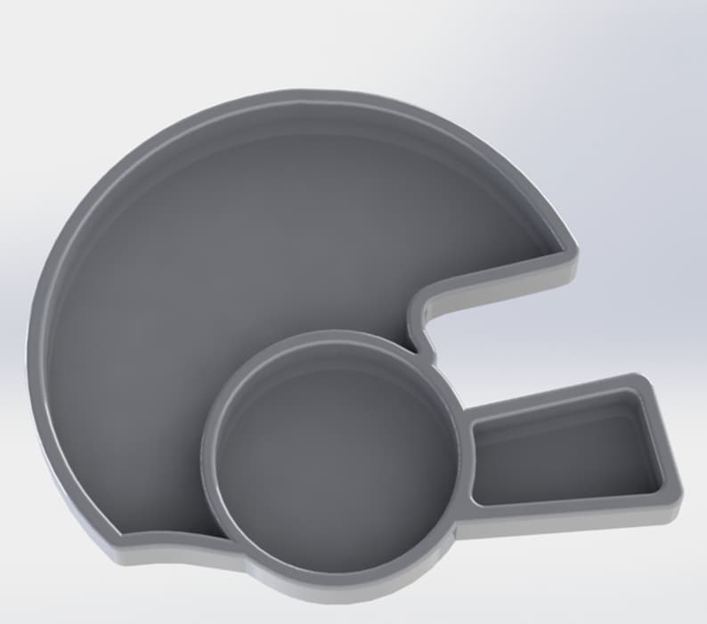 Puede incluir: Una bandeja de pl&aacute;stico gris con forma de casco de f&uacute;tbol americano. La bandeja tiene dos compartimentos, uno grande y uno peque&ntilde;o.