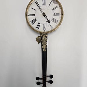 Reloj de pared vintage Timeworks con forma de violín: decoración musical estilo Stradivarius con detalle de péndulo.