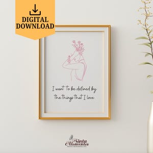 May include: A framed art print with a gold frame. The print features a minimalist line drawing of a person with flowers and the text "I want to be defined by the things that I love." A digital download.