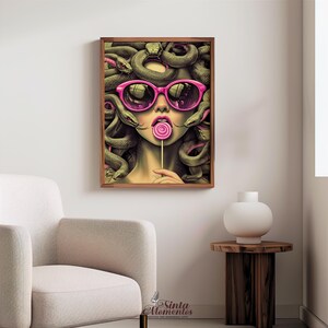 May include: A framed art print featuring a stylized illustration of Medusa with snakes for hair, wearing pink sunglasses and holding a lollipop. The artwork has a modern, pop art style with vibrant colors and a playful theme.