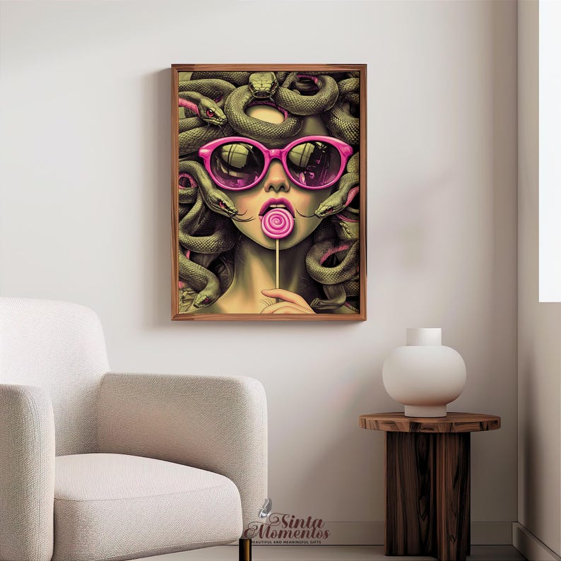 May include: A framed art print featuring a stylized illustration of Medusa with snakes for hair, wearing pink sunglasses and holding a lollipop. The artwork has a modern, pop art style with vibrant colors and a playful theme.