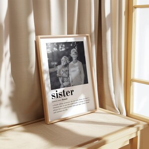 May include: Black and white photograph of two siblings, a boy and a girl, standing in a woodland. The photo is framed and includes a definition of the word "sister" with the name "Hannah" underneath.