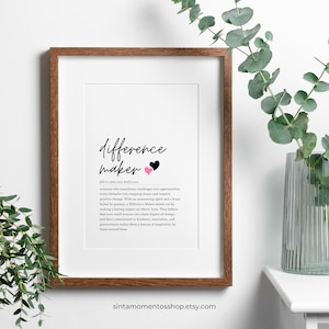 May include: A printable definition of the word "difference maker" with two pink and black hearts. The definition reads: "Someone who transforms challenges into opportunities, turns obstacles into stepping stones and inspires positive change. With an unwavering spirit and a heart fueled by passion, a Difference Maker stands out by making a lasting impact on others' lives. They believe that even small actions can create ripples of change, and their commitment to kindness, innovation, and perseverance makes them a beacon of inspiration for those around them."