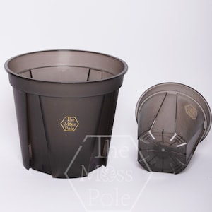 May include: Two black plastic plant pots with drainage holes. The larger pot has the text "The Moss Pole" printed on the side.