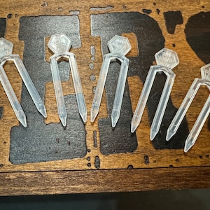 May include: Five clear plastic forks with a hexagonal handle. Each handle has the text "FORK" printed on it.