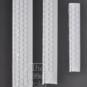 May include: Three white plastic honeycomb-patterned wall trim pieces. The trim pieces are different lengths. The text "The Moss Pole" is visible in the image.