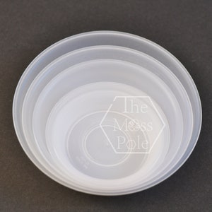 May include: Three clear plastic bowls of varying sizes stacked on top of each other. The bowls are translucent and have a smooth, glossy finish.