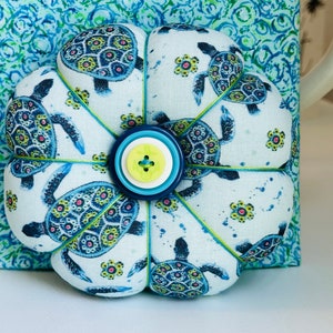 This beautiful Sea Turtles cushion in beachy blues and greens has ocean swirl on the back and anchor buttons on both sides.Anyone who enjoys the ocean or these amazing creatures would love this pincushion.