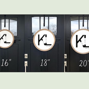 May include: Three round wooden signs with a white center and a black logo that says "KL KATIE LEWIS designs". The signs are 16", 18", and 20" in diameter, respectively, and are hanging on black doors.