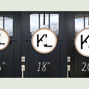 May include: Three round wooden wreaths with a white background and black lettering. The wreaths are 16 inches, 18 inches, and 20 inches in diameter. The lettering on the wreaths reads "Klay Lewis Designs".