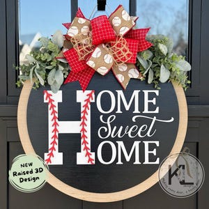 Peut inclure: Une suspension de porte en bois noir et blanc avec le texte "HOME Sweet HOME" en lettres blanches. La lettre "H" est d&eacute;cor&eacute;e de coutures rouges pour ressembler &agrave; un ballon de baseball. Un n&oelig;ud rouge et beige avec un tissu &agrave; th&egrave;me de baseball est attach&eacute; au sommet de la suspension de porte.