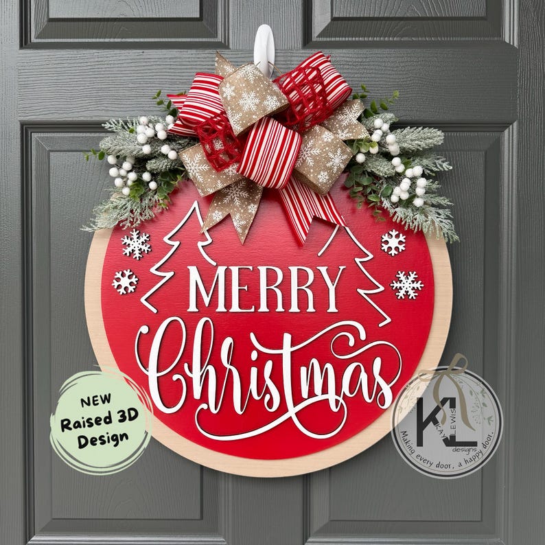 May include: A round wooden door sign with a red center and light wood border. It features the white text Merry Christmas, two white tree outlines, and white snowflakes. A large bow with red stripes and tan snowflake patterns sits atop, accented by frosted greenery and white berries.