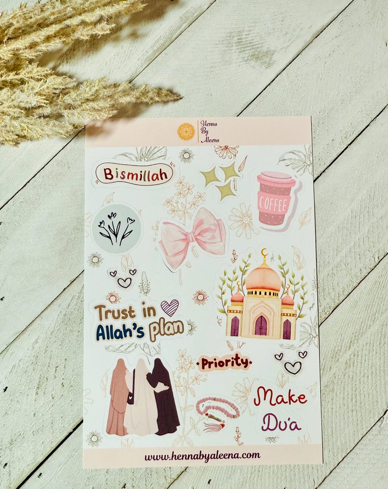 May include: A sticker sheet featuring Islamic-themed designs. It includes a pink bow, a mosque illustration, and phrases such as "Bismillah" and "Trust in Allah's plan." A coffee cup and floral elements are also present. The website address "www.hennabyaleena.com" is displayed.