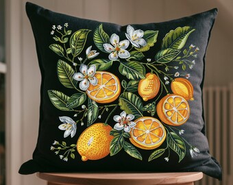 May include: Black throw pillow with a floral design featuring white blossoms and yellow lemons on a black background.