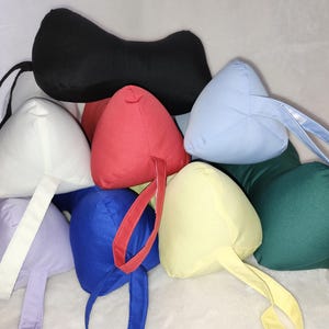 May include: Assortment of colorful triangular pillows with handles. The pillows are made of fabric and come in a variety of colors, including red, blue, green, yellow, and white.