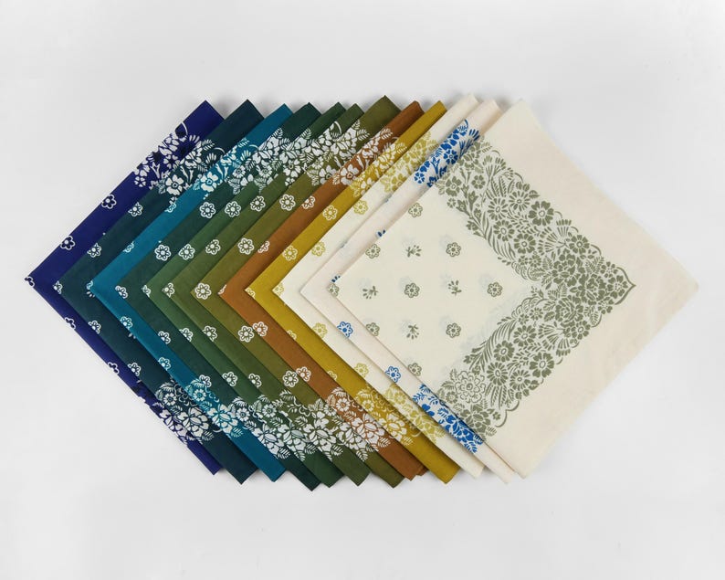 May include: A collection of square bandanas in various colors, arranged in a fan shape. The bandanas feature floral patterns and border designs. Colors include navy, teal, green, olive, gold, and cream. The bandanas are made of fabric.