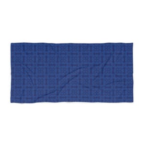 May include: A rectangular, blue patterned towel. The towel features a repeating geometric design in varying shades of blue. The pattern is a series of interconnected shapes, creating a textured appearance. The towel is likely made of a soft fabric.